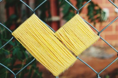 Close-up of heart shaped wool on chainlink fence