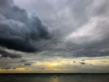 Scenic view of sea against storm clouds