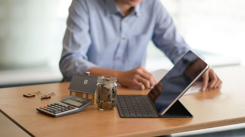 Midsection of man using laptop on table