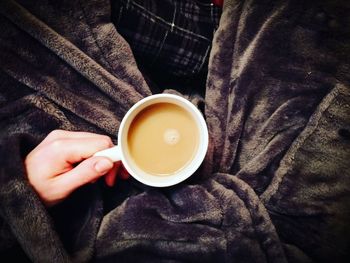 High angle view of hand holding coffee cup