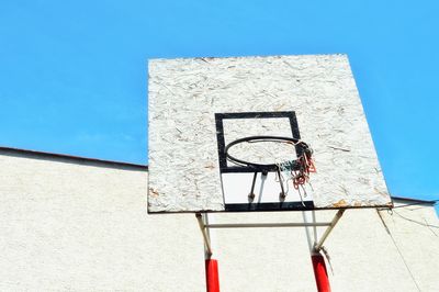 Low angle view of basketball hoop against blue sky