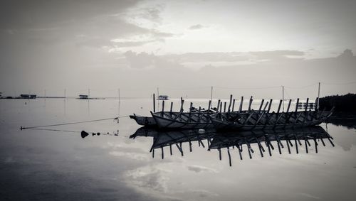 Boats moored on sea against sky