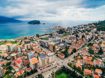 High angle view of townscape by sea against sky