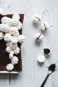 Meringues with chocolate filling on kitchen table 