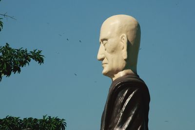 Low angle view of statue against clear blue sky