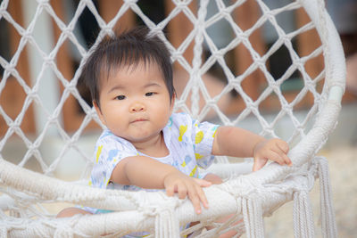 Portrait of cute baby girl outdoors fence