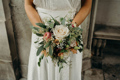 Midsection of woman holding rose bouquet