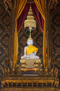 Low angle view of buddha statue against building