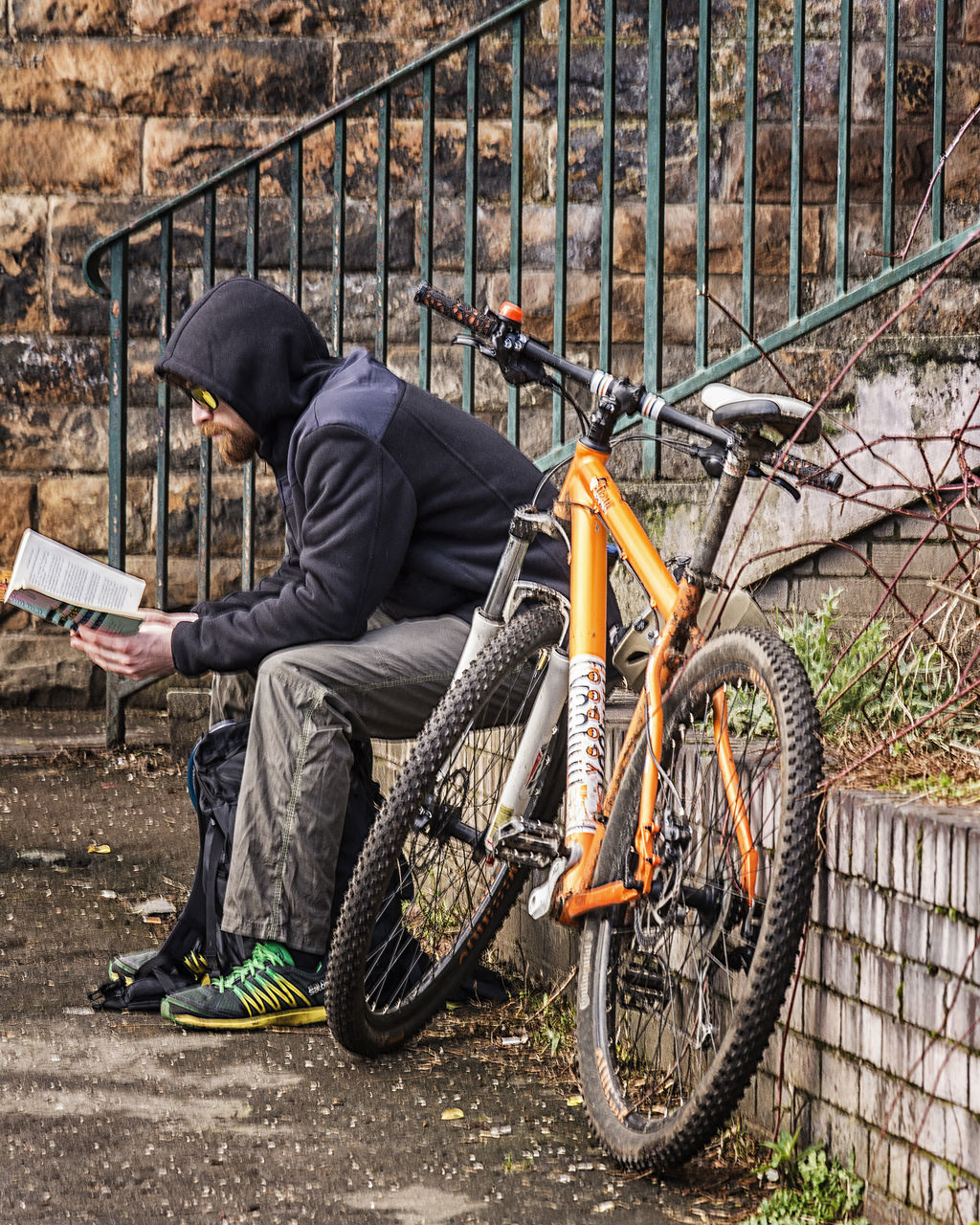 bicycle, mode of transport, transportation, land vehicle, stationary, parked, architecture, built structure, one person, building exterior, day, outdoors, parking, metal, side view, leaning, fence, graffiti, railing, abandoned