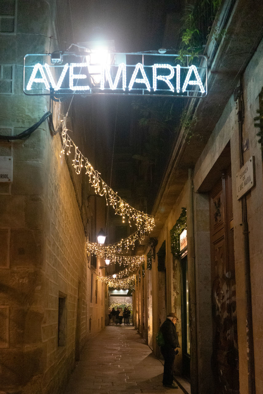 architecture, illuminated, night, built structure, city, text, road, urban area, street, alley, lighting equipment, building exterior, communication, light, infrastructure, the way forward, lighting, western script, building, sign, outdoors, no people