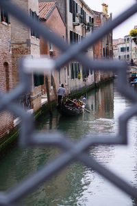 Man with pigeons on bridge over water