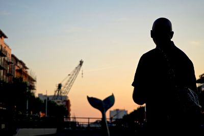 Silhouette man looking at sunset