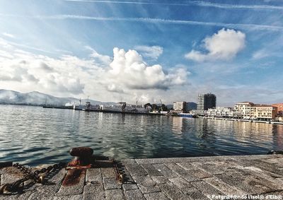 River by buildings in city against sky