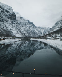 Scenic view of lake by snowcapped mountains against sky