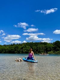 Man in boat on lake against blue sky