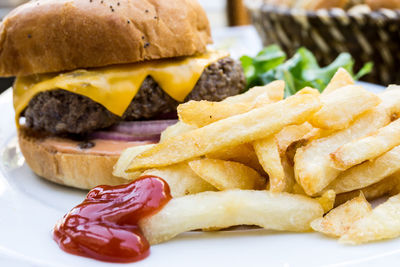 Close-up of burger with french fries in plate