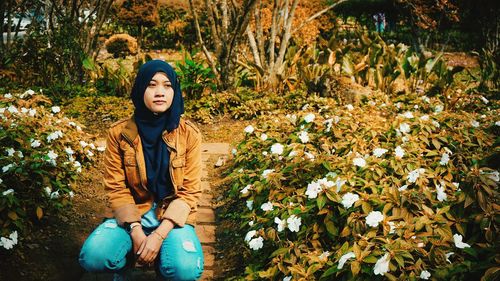 Portrait of smiling young woman sitting in park