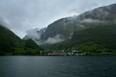 Scenic view of lake by mountains against sky