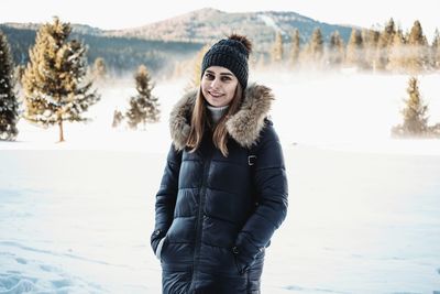 Portrait of young woman standing in snow