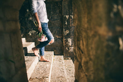 Low section of man standing on retaining wall