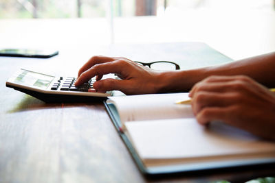 Close-up of man using mobile phone on table