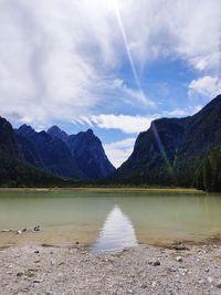 Scenic view of lake by mountains against sky