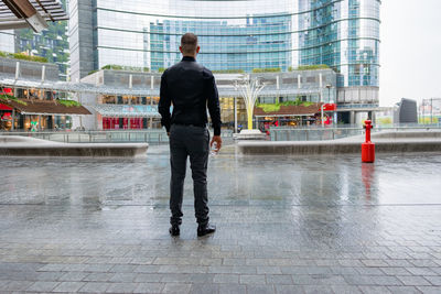 Full length rear view of man standing in city