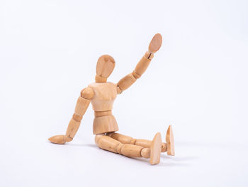 Close-up of figurine on wood against white background