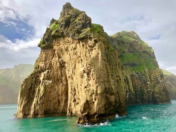 Scenic view of rock formation in sea against sky