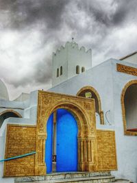 Low angle view of building against cloudy sky
