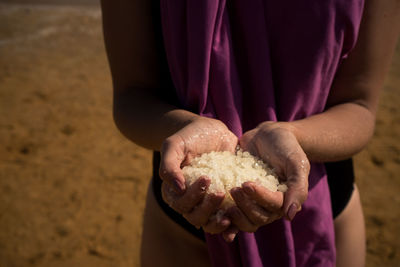 Close-up of woman holding salt from dead sea