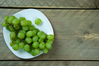 High angle view of grapes in plate on table