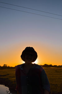 Man standing on land against sky during sunset