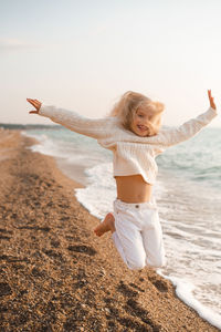 Happy girl jumping at beach