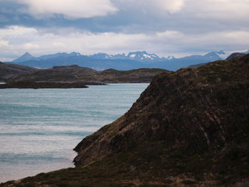 Scenic view of sea and mountains against sky