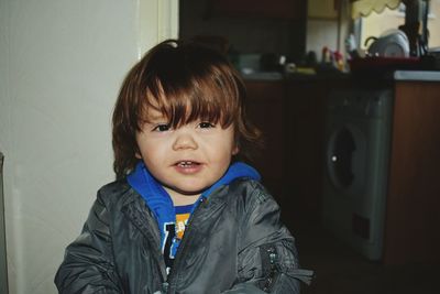 Portrait of cute boy standing in kitchen