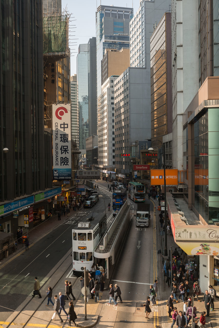 building exterior, architecture, city, transportation, built structure, land vehicle, mode of transport, street, car, city life, city street, road, building, traffic, incidental people, on the move, road marking, bicycle, office building
