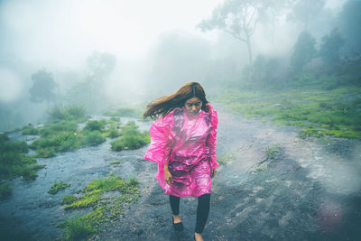 Woman standing on mountain during rainy season