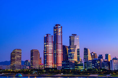 Skyscrapers in city against blue sky