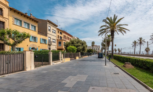 Footpath amidst buildings against sky