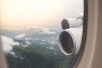 Airplane flying over landscape against sky