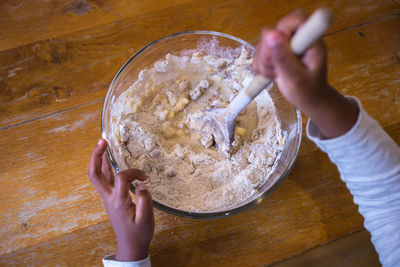 High angle view of person preparing food in bowl on table