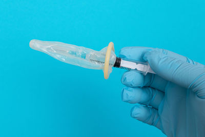 Close-up of human hand against blue background