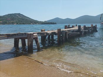 Wooden posts on beach against clear sky