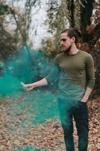 Young man looking away in forest