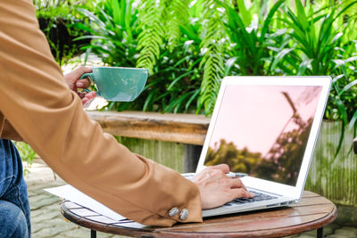 Low section of man using laptop at table