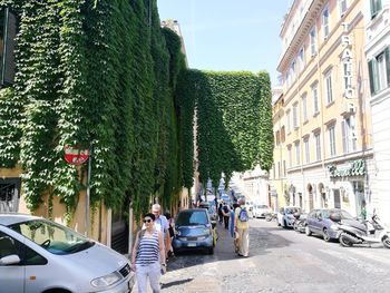Cars on city street against sky