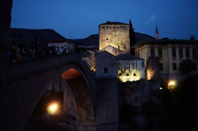 Illuminated building against sky at dusk