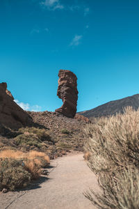 Rock formations on landscape against blue sky