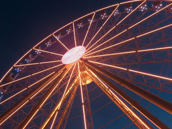 Low angle view of illuminated ferris wheel against sky at night